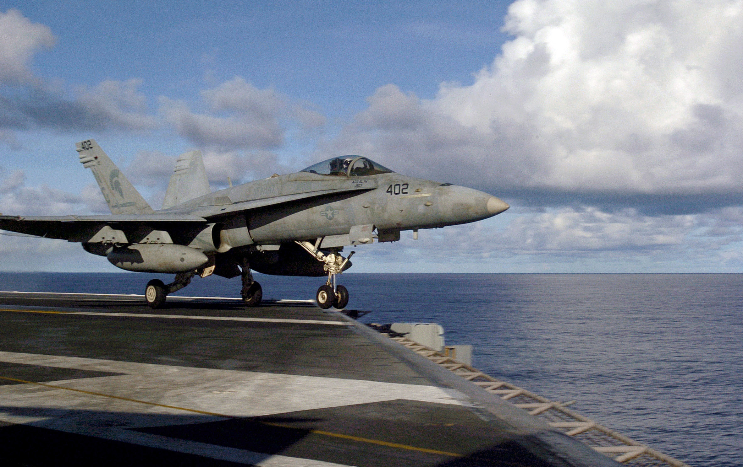 This is an image of an F/A-18C Hornet taking off from a flight deck.